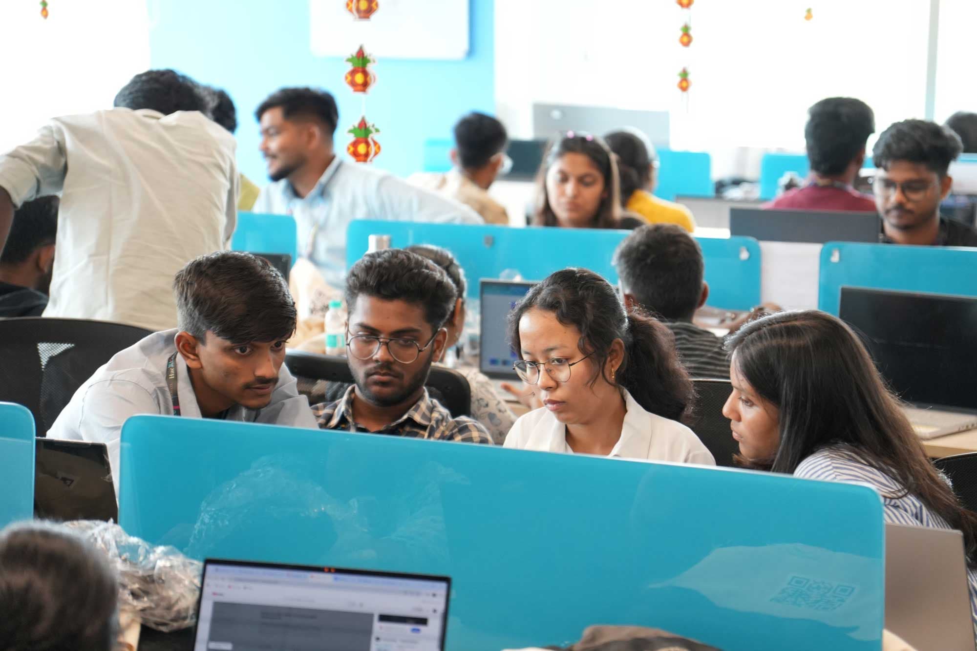 A team working together on their project at HacXLerate