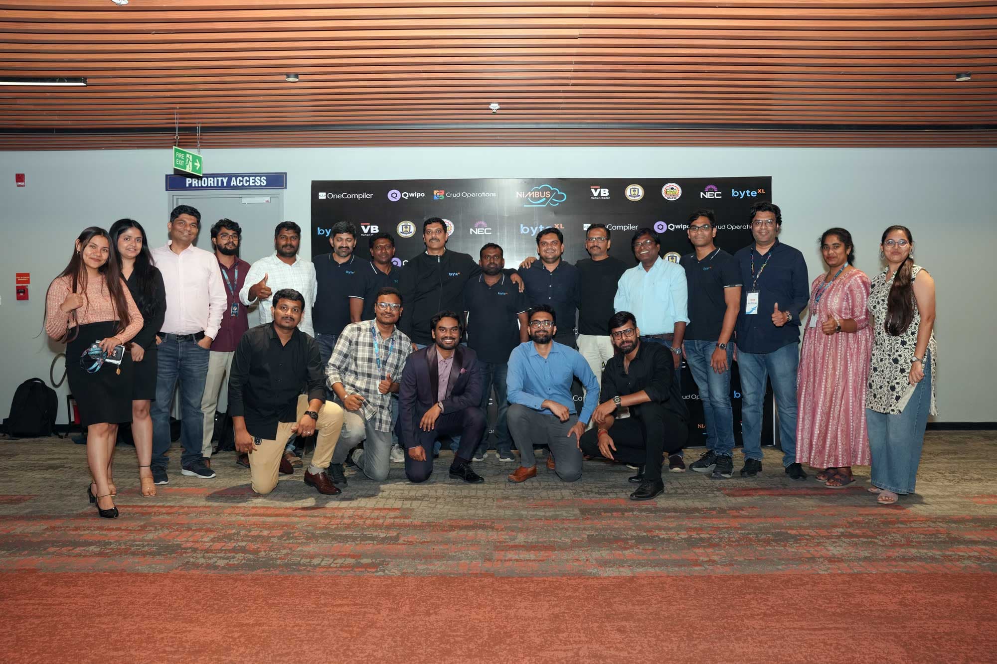 Organizers and mentors in front of the HacXLerate backdrop